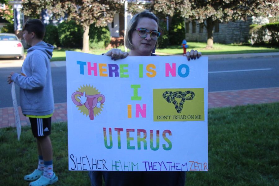 Ashley Saunders holds a sign that says there is no I in uterus. 