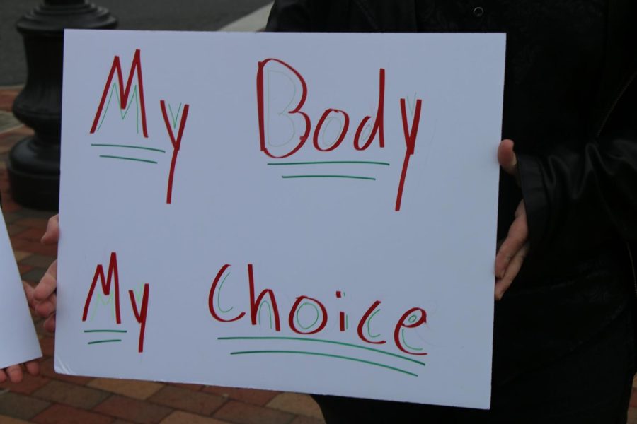 The sign used by the three protester says my body, my choice. 