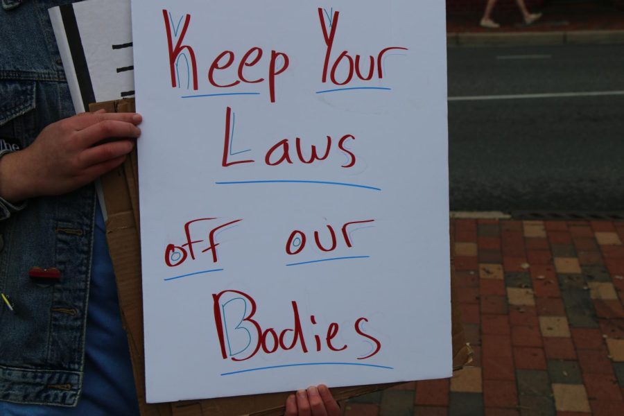  Rowan Whitmeyer holds a sign that says keep your laws off our bodies. 