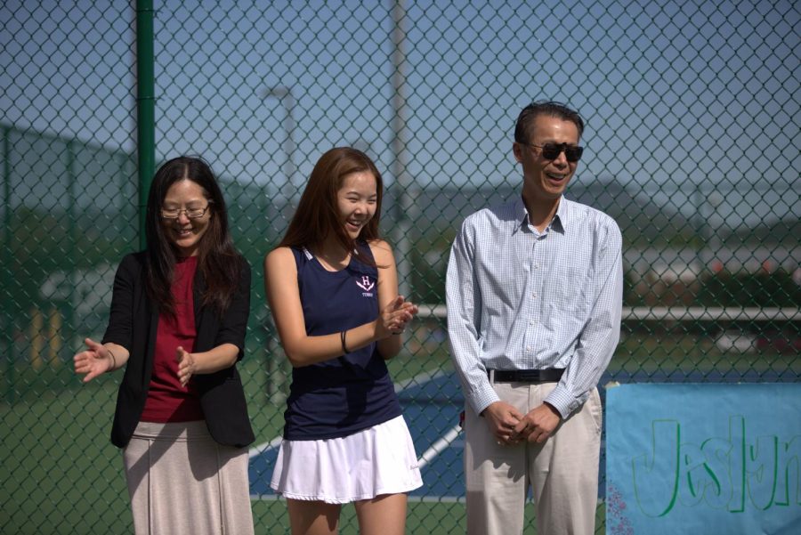 Senior Jeslyn Liu claps with her parents. 