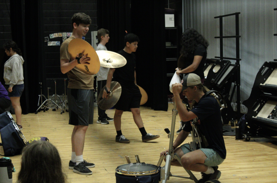 On the first day of band camp students set up instruments on stage for practice. 
