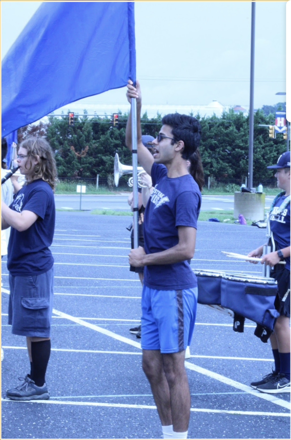 The band practices together with the music. Some play their instruments while others in colour guard, practice their flag routine. 