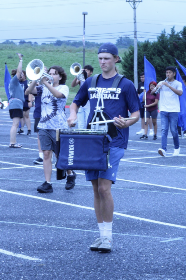 The band director, Claire Leeper, instructed band students to walk from one end of the parking lot to the other while practicing to play. 