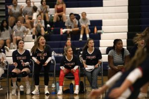 Junior Rylee Stroop and sophomores Chloe Dameron and Veronica Gutierrez cheer teammates on while benched due to various injuries. All three are normally starters.  