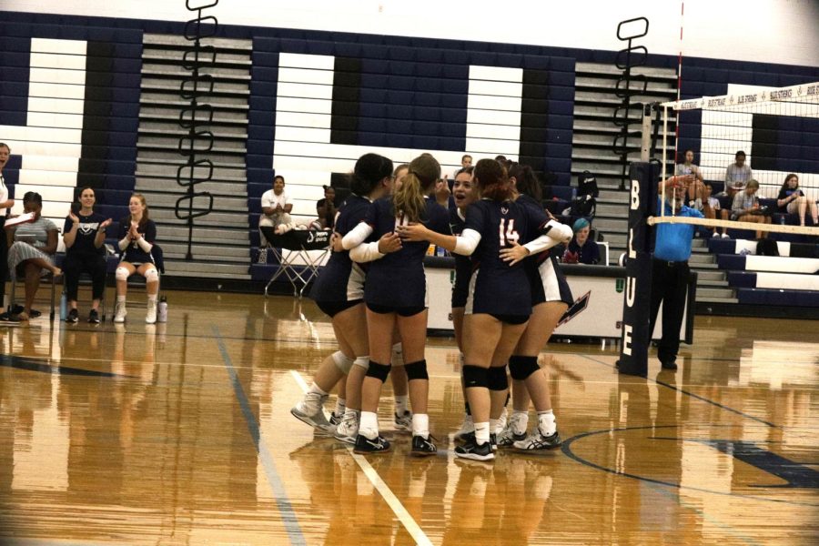 Starters cheer after getting the first point of the game against Millbrook Patriots. Sophomore Tegan Miller served the point. 