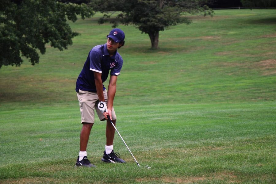 Sophomore Javier Molina looks at the hole and lines up his second shot before he hits the ball.