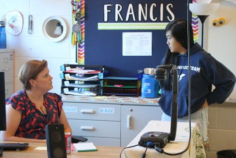 English and debate teacher Danae Delozier talks to a student during the after school debate team meeting. 