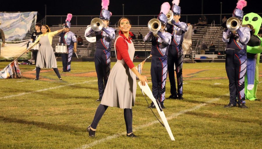 Sophomore Amy Sanchez twirls rifle as part of color guard. Color guard was dressed as artists in the masterpiece theme. 
