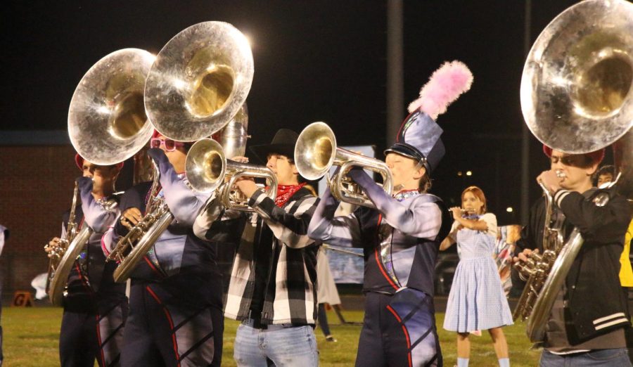 Students play the mellophone and sousaphone during half time. The half time theme is masterpiece, focusing on art and music. 
