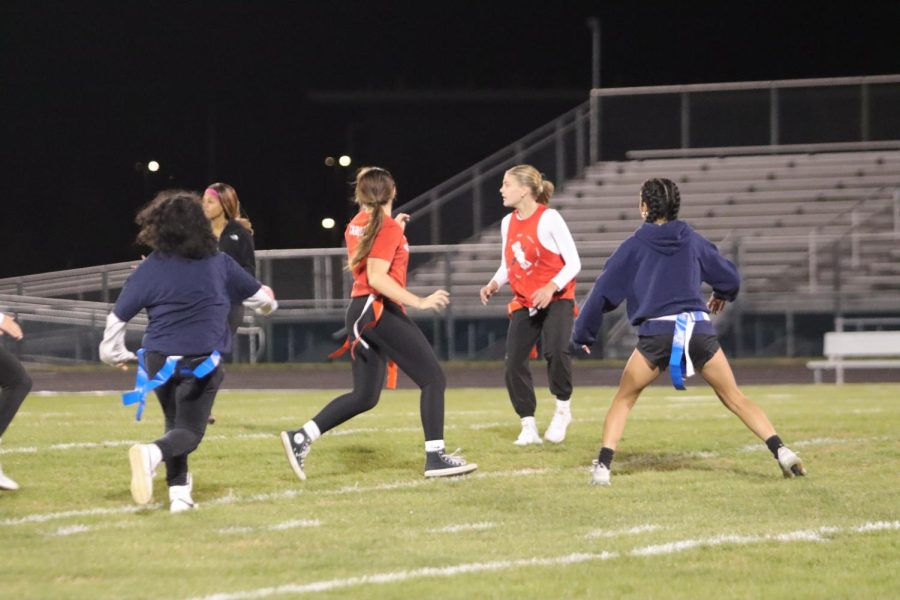 Junior Caroline Shanholtz runs after senior with the ball during powderpuff. The two teams are coached by current football players. I was excited to play this year because it was fun to watch last year and it was exciting to learn how to play from the football players, Shanholtz said. 