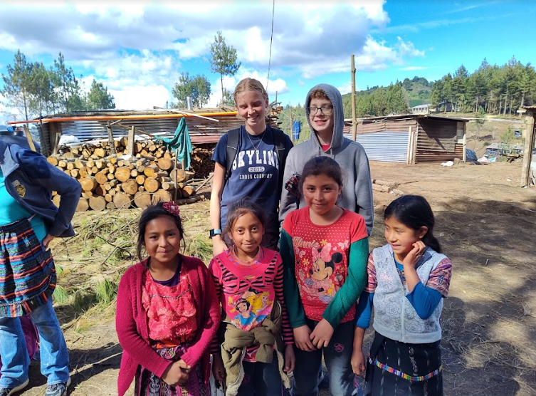 Junior+Lena+Blagg+and+freshman+Micah+Blagg+pose+for+a+picture+with+children+in+the+Guatemalan+village+they+stayed+in.