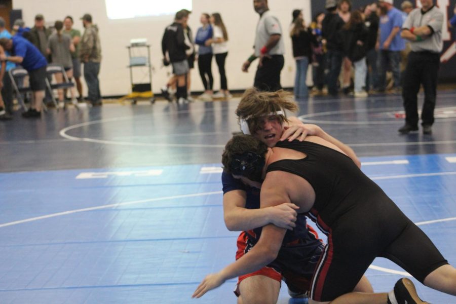 Freshman Addison Grant goes up against his opponent in his wrestling match.  