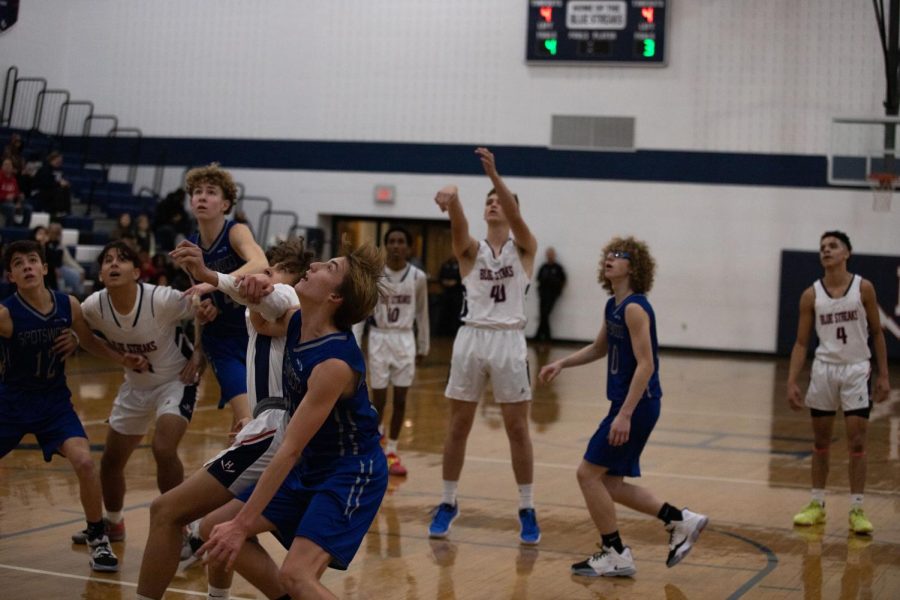 Players run to the net after sophomore Lucas Swarts shoots a free-throw. 