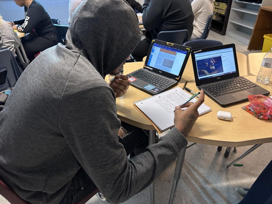 Senior Cadren Whitelow transferring the information from his canvas website into his notebook. 