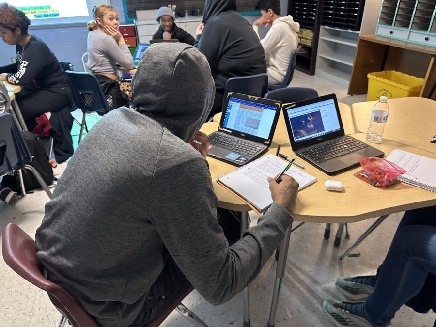 Senior Cadren Whitelow looking at his Chromebook to see the notes he needs to transfer into his notebook. 