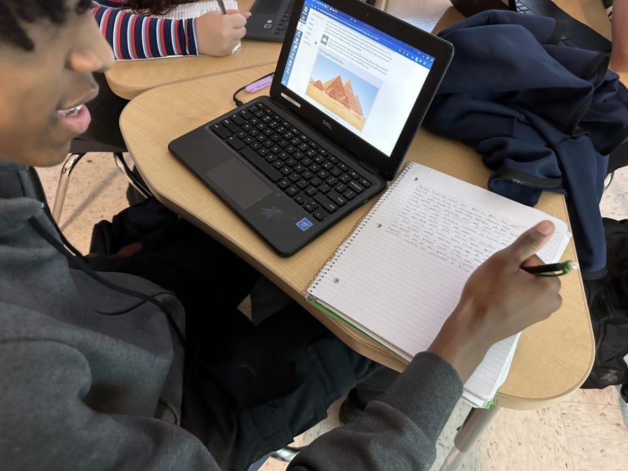 Sophomore Tiberius Fields writing his notes on African American history . 