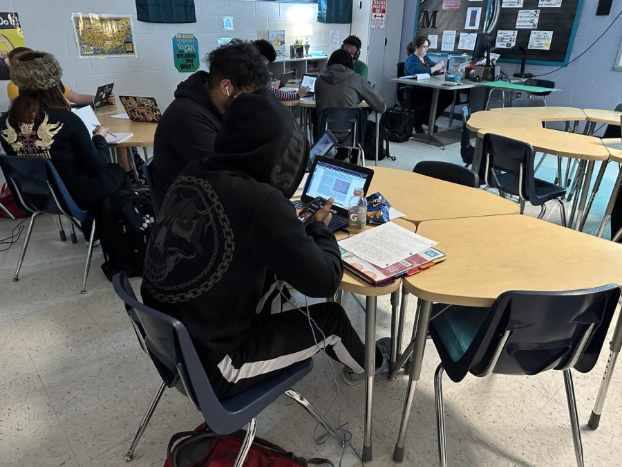 Junior Charles Blair with his chromebook and notebook doing his history classwork. 