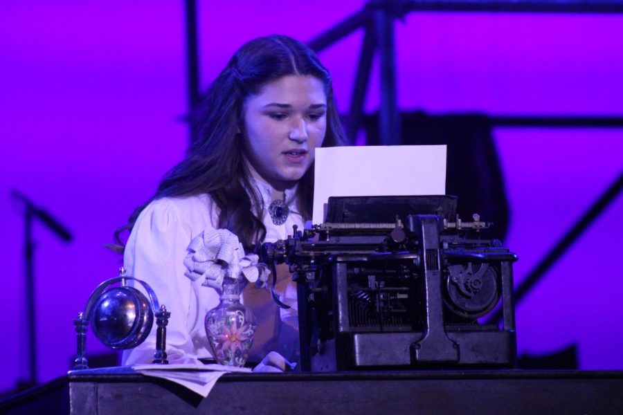 Katherine Plumber, played by senior Ella Young, sings 'Watch What Happens'. Young's character is a journalist who tries to write a successful story in a male-dominated career during the late 1800s. 