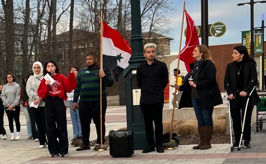 George+Mason+staff+and+students+stand+next+to+a+Syrian+flag+and+a+Turkish+flag+during+a+moment+of+silence+in+the+candle+vigil.