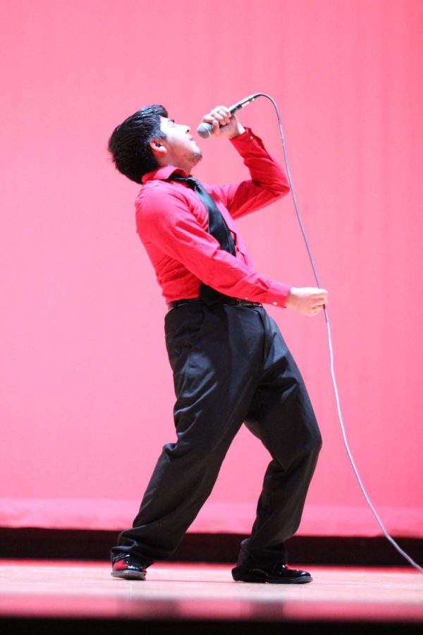 Senior Alexis Calderon-Cardoso puts on a show as he sings at the talent show, March 3.