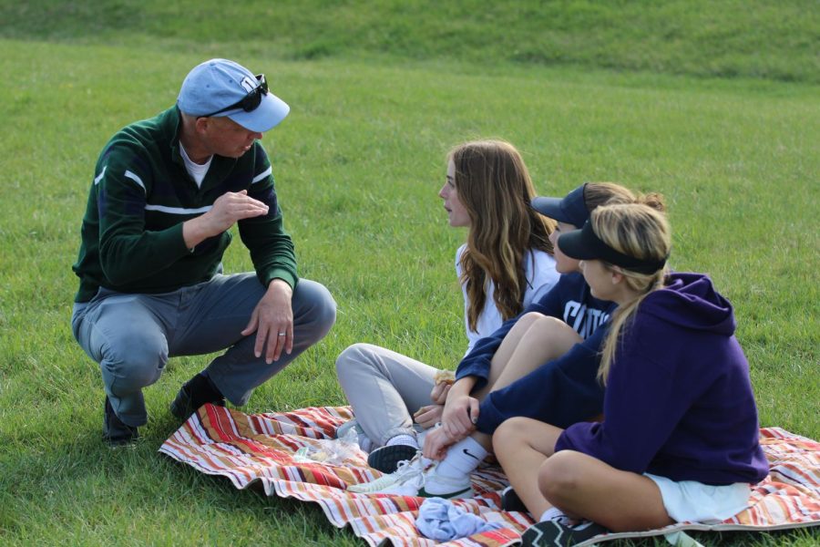 Coach Lawson Yoder talks to sophomores Macy Waid, Sequoia Hall and Teagan Miller while they watch the games.