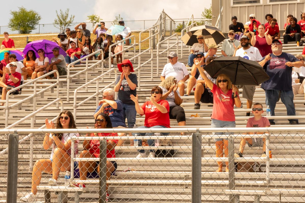Supporters in the stadium cheer for the football team. They wore red in remembrance of Calour Fields. 