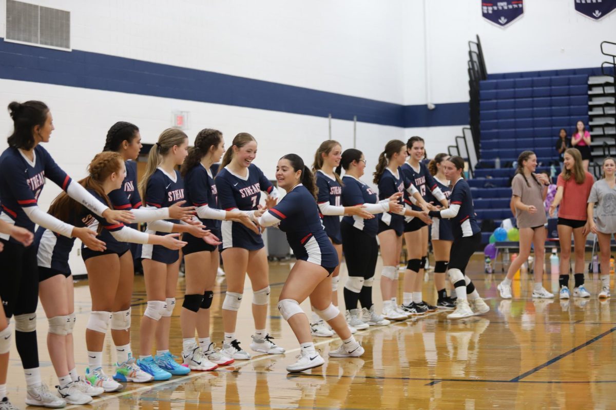 The+Girls+Varsity+Volleyball+team+does+a+handshake+train+before+their+game+against+the+Strasburg+Rams+Aug.+24.