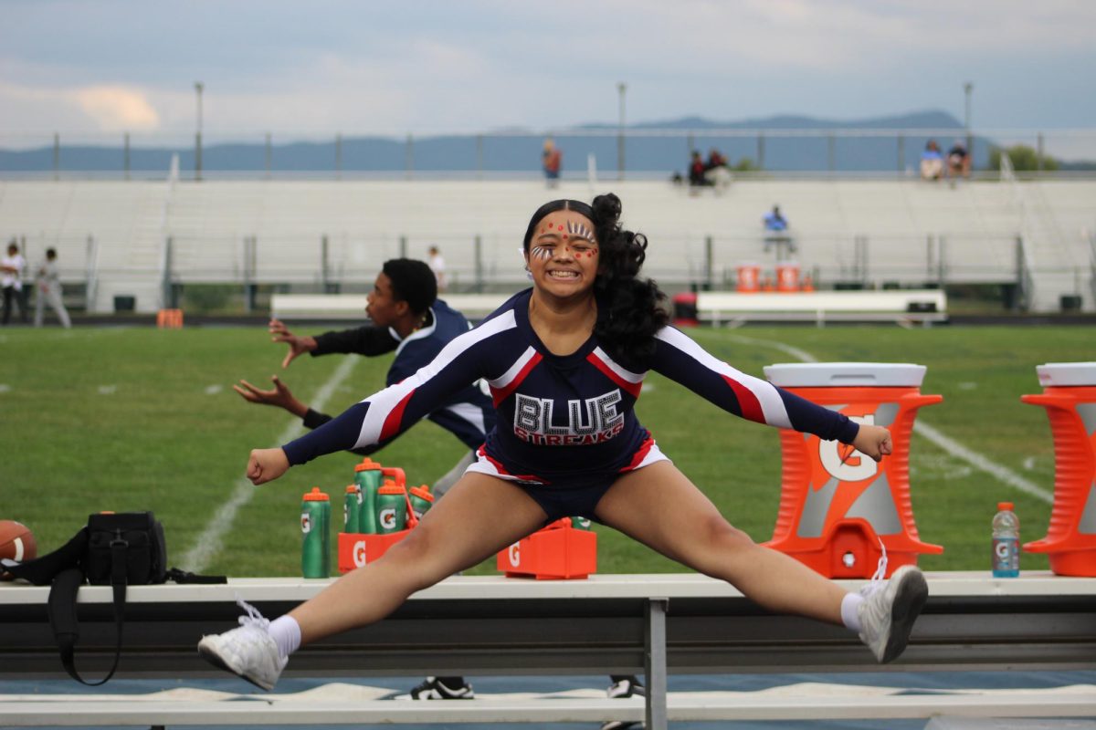 Freshman Kaylee Sychampanakhone does a split jump on the sideline of the JV football game.