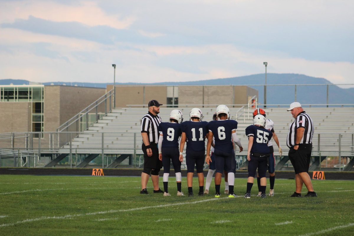 Jv captains Perry, Martinez, Arrington, and Colley meet with the other teams captains before kickoff.