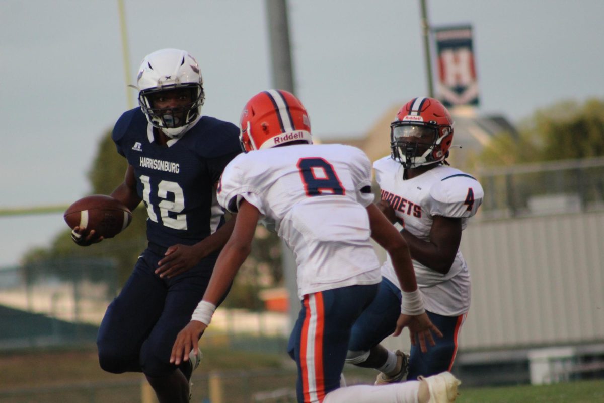 Sophomore Antonio Petty runs the ball attempting to get around  the Orange County defender. 