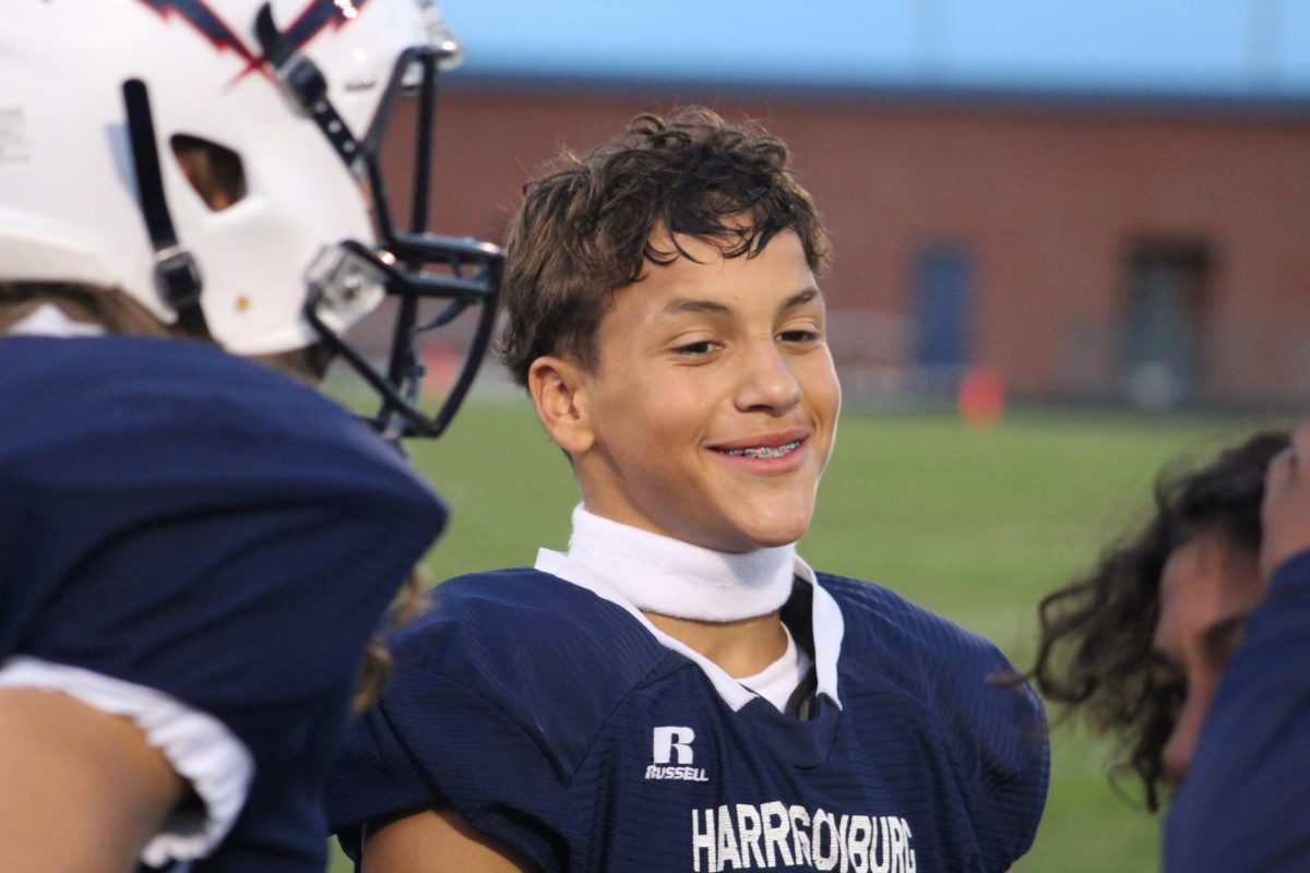 8th grader Jarren Engle smiles on the sideline after a good play.