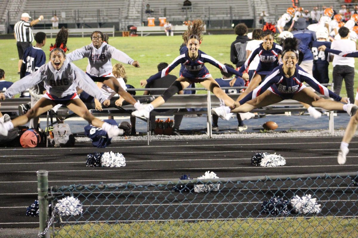 JV cheer team does a stunt facing the crowd. 