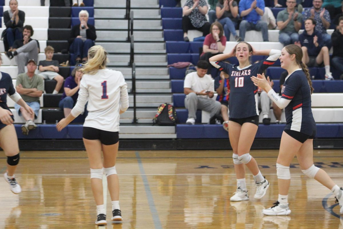 Junior Macy Waid and Junior Veronica Gutierrez celebrate with their team after winning the point.