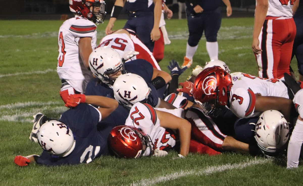 The varsity football team tackles a player from East Rockingham.