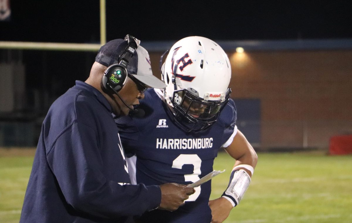 Senior JJ Engle gets some advice from his coach before a play.