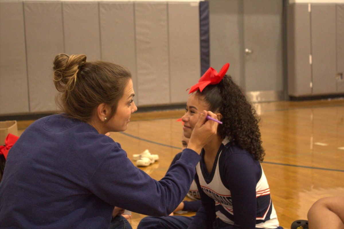 JV cheer coach prepares 8th grader Emma Rodriguez to compete.