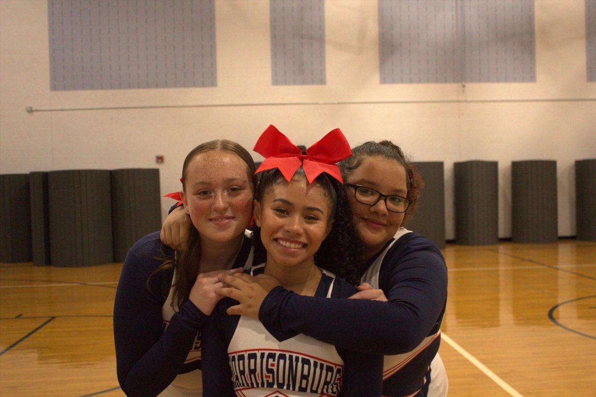 JV cheer captains Lilian-Rae Colley, Jazlynn Robinson-Jenkins, and Co-Captain Emma Rodriguez pose for a captains photo.