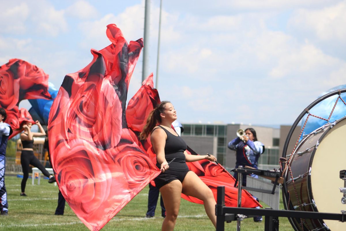 Junior Thailiz Matoe-Alvarado flares flag during half time performance.
