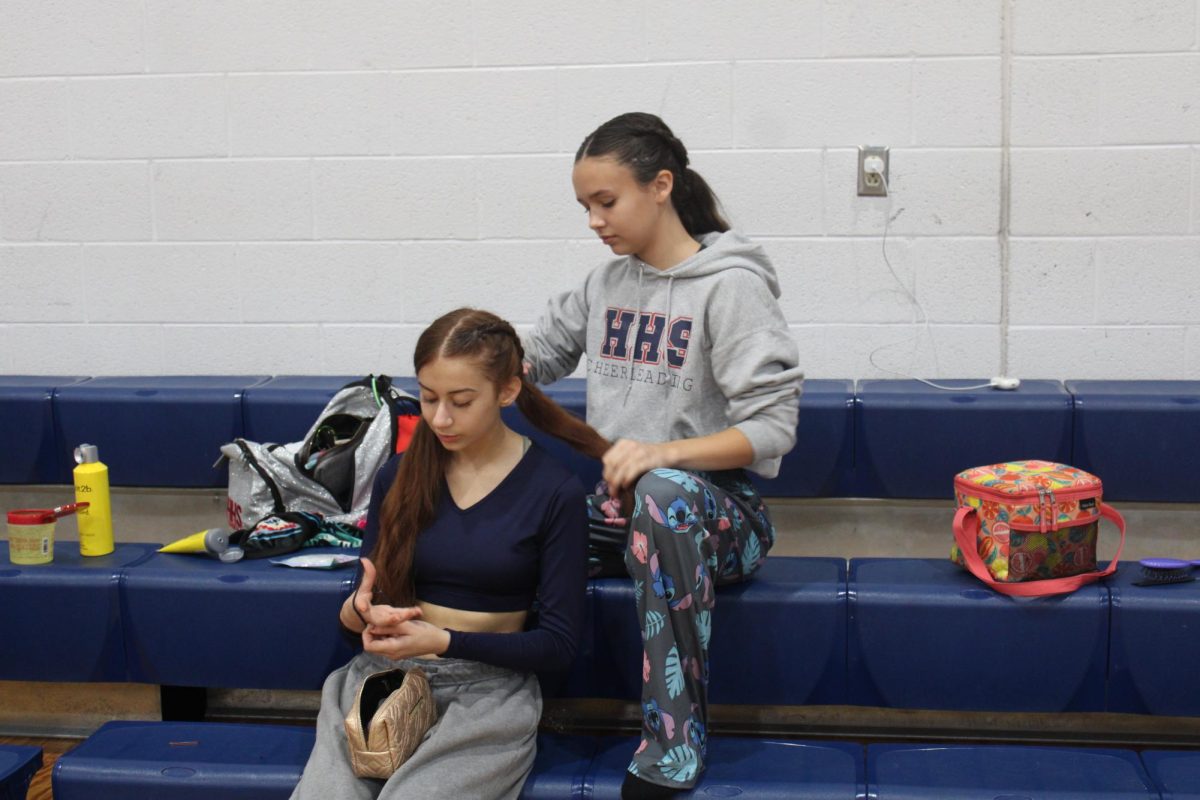 8th grader Danica Doberstein braids her teammate, Liva Jwanmerys hair.
