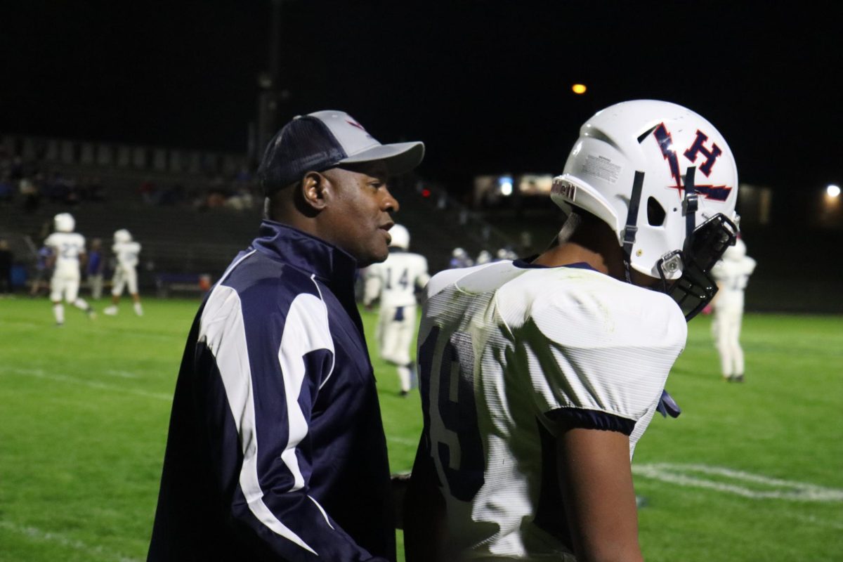 Freshman Robert Anderson talks to coach on the sideline.