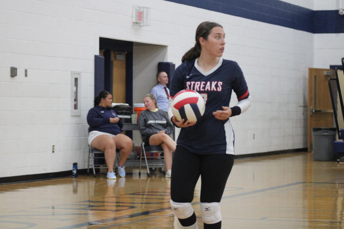Senior Rylee Stroop getting ready to serve the ball.