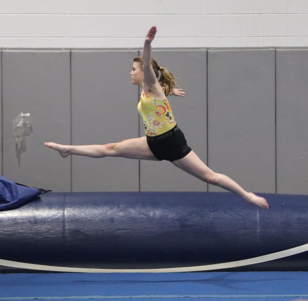 Sophomore Jossalynn Hartman does a leap at practice during warm ups. 