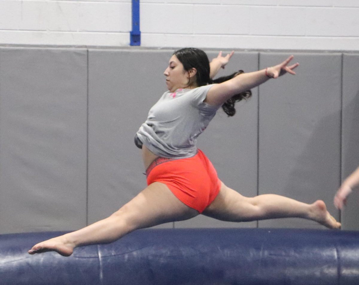 Senior Kimberly Ortiz does a leap jump during warmups at practice. 