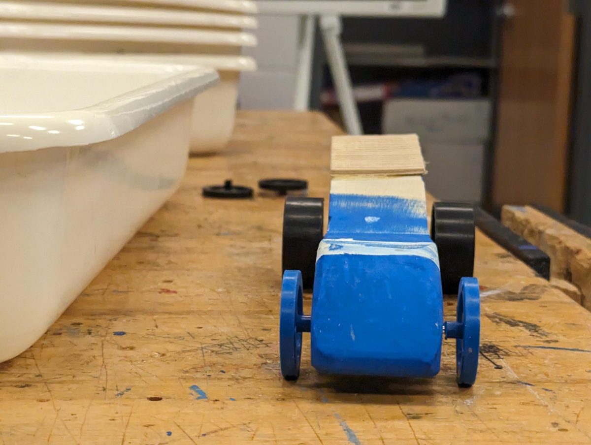 Unfinished Wooden Race Car sits on tabel. 