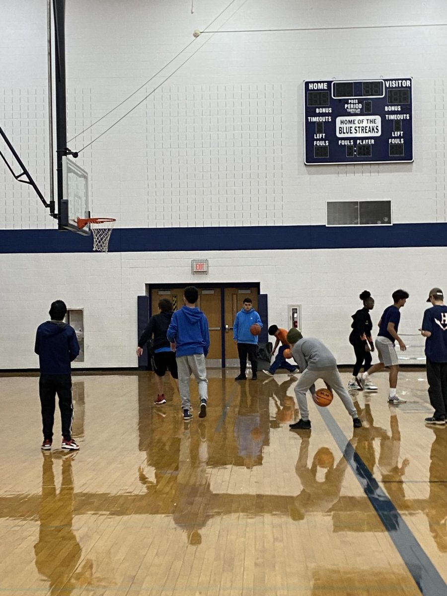 Students dribble their basketballs during gym class.