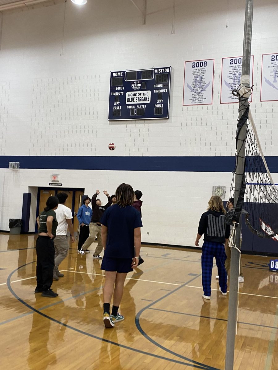 Student sets the volleyball to other teammates in PE.