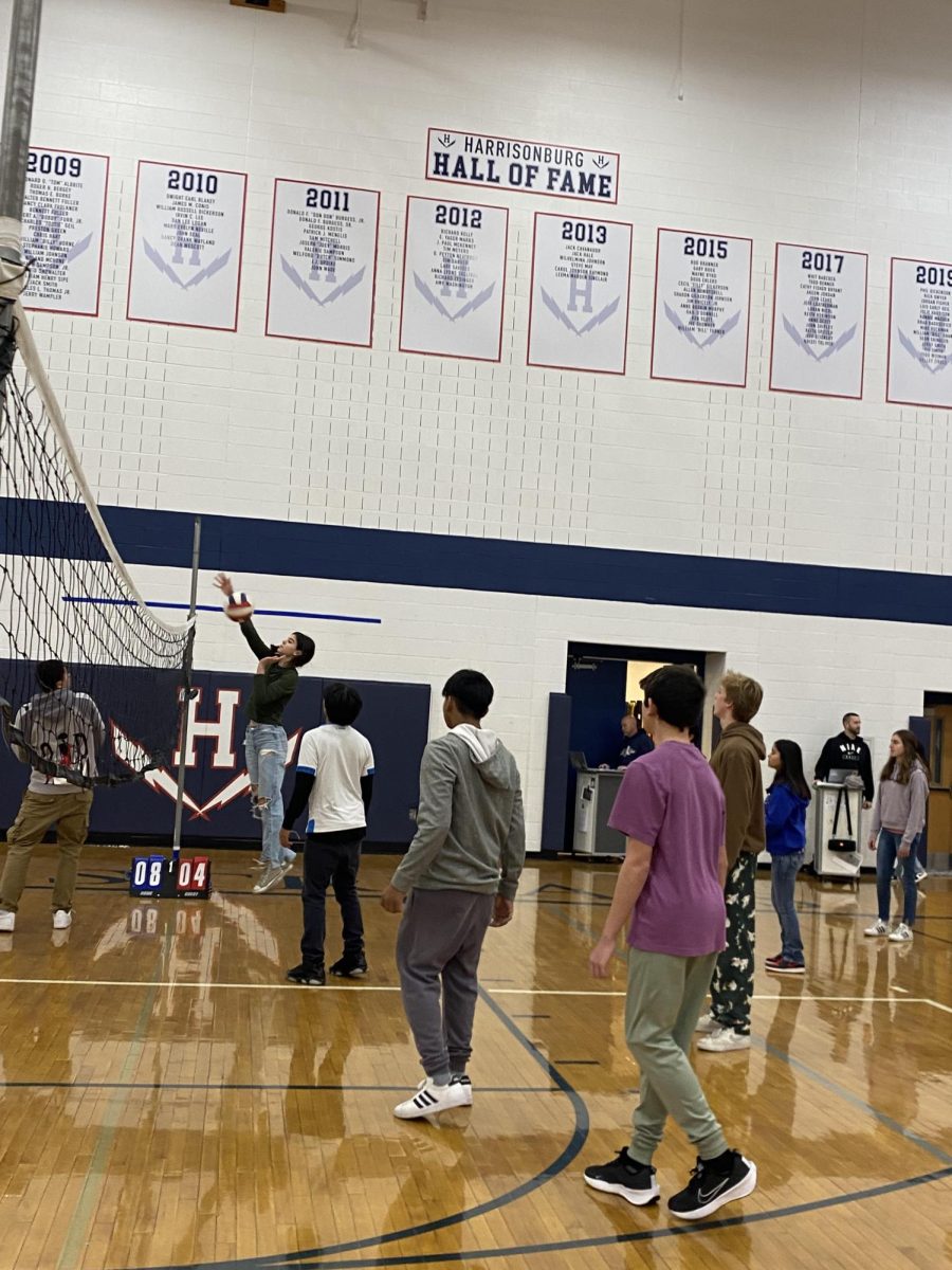 A student jumps up to spike the volleyball.