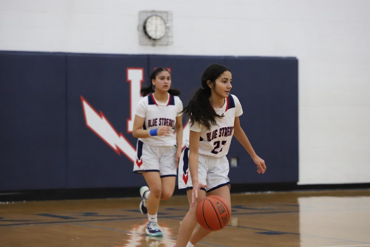 Nayeli Amaya dribbles the ball down the court. 