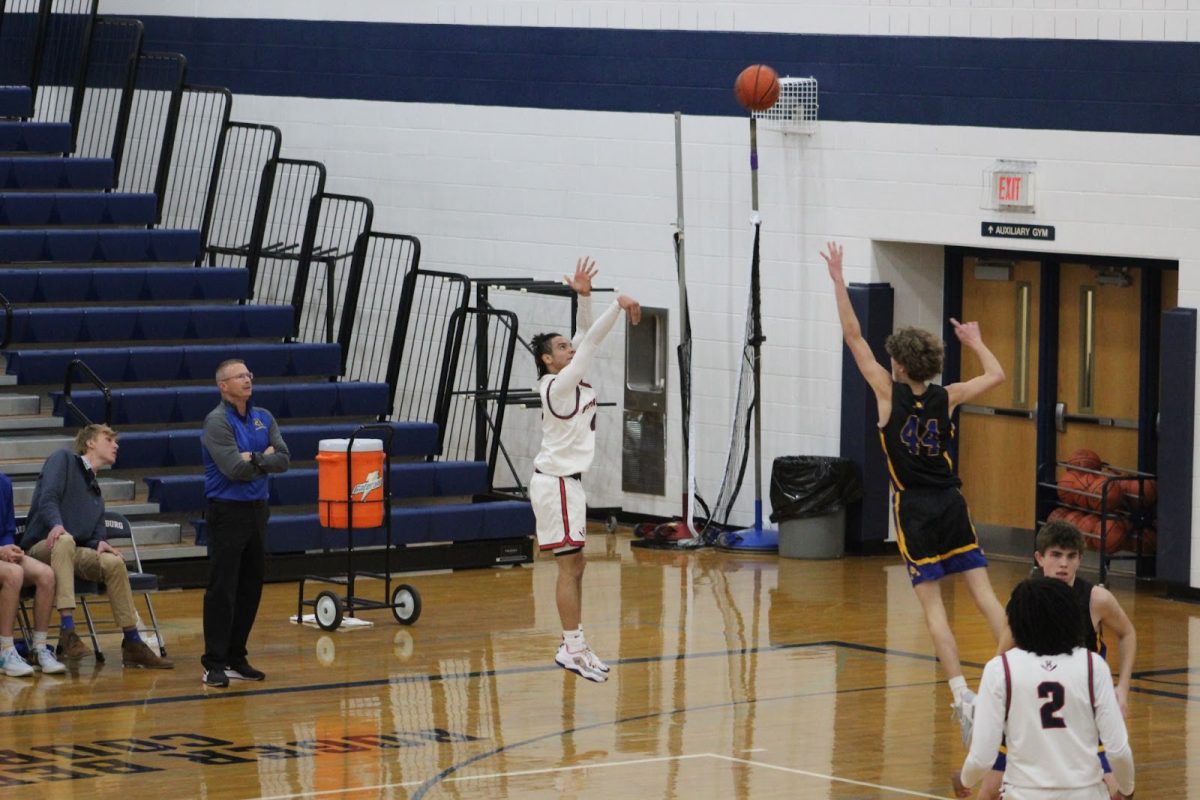 Junior Lazaro Valdivia shoots a three-pointer in front of a defender.