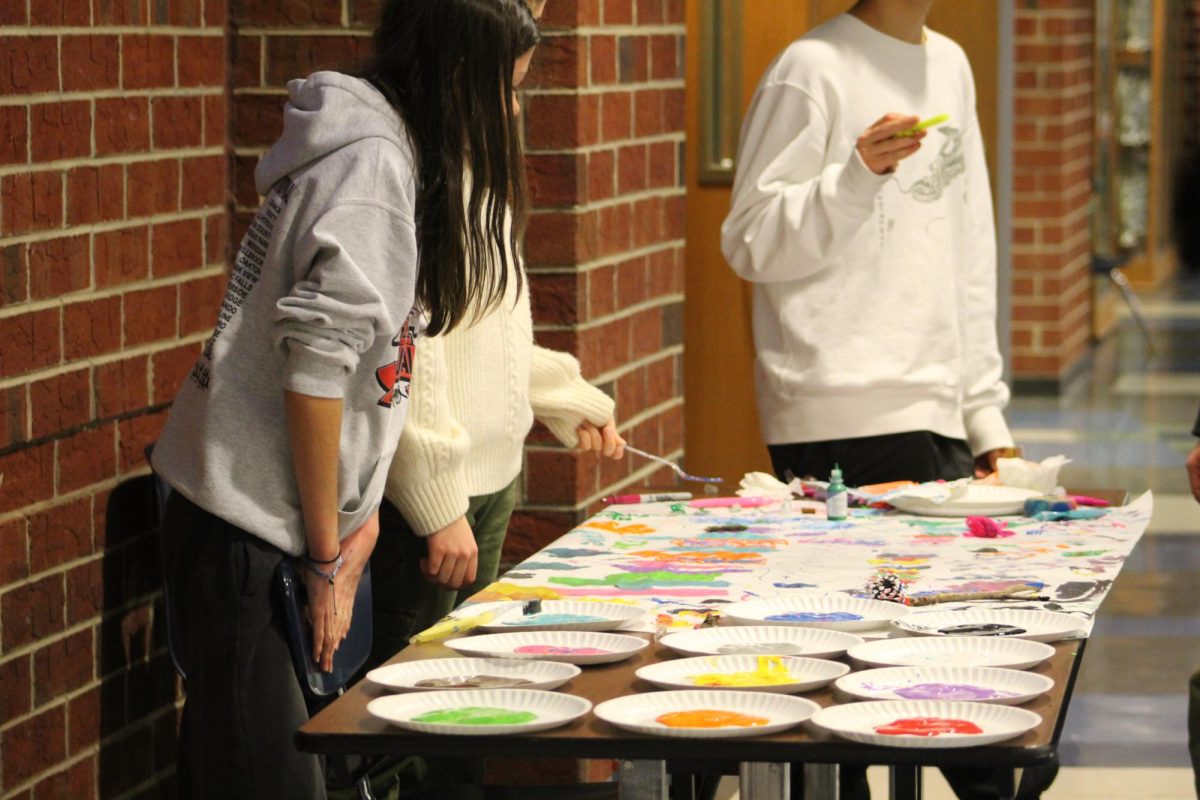 Students paint with different materials at the painting station.